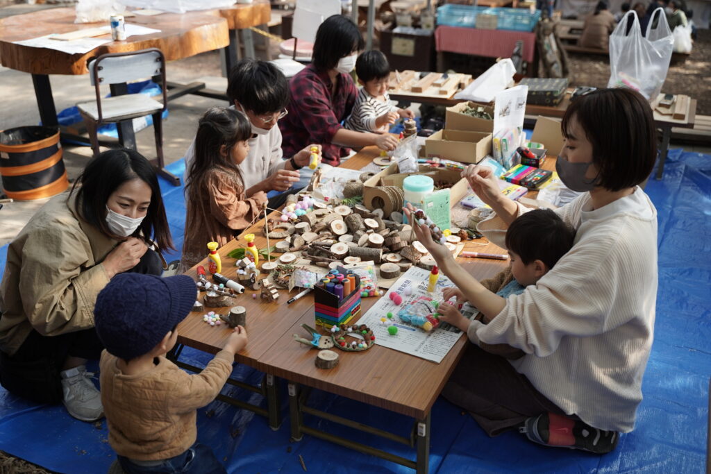 親子で木の実や木片を使った工作を楽しむ様子